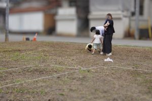 転ぶ息子を助ける父親、見守る母親、駆け寄る姉